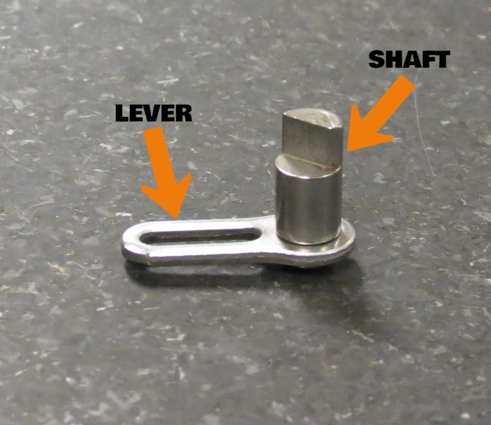 Shaft and lever metal components assembled in stamping press